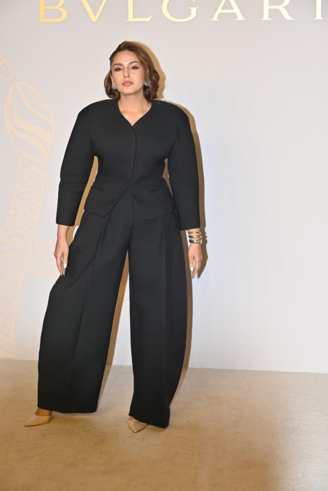 Huma Qureshi posed on the red carpet in an all-black baggy attire. She wore a loose shirt and matching bottoms. She kept her look minimal with sparkling earrings and dainty golden bracelet. 
